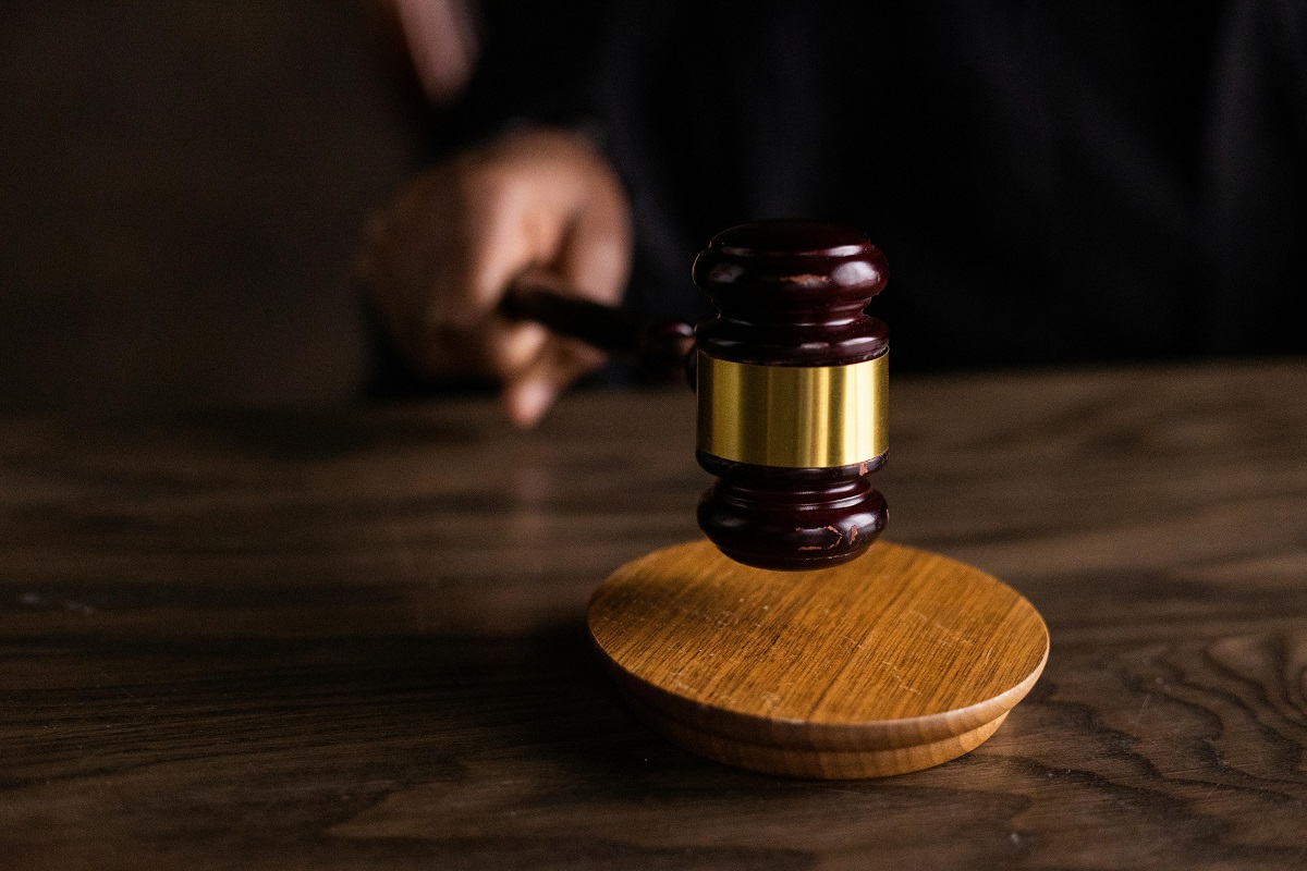 close-up of a judge's hand holding a gavel, poised to strike