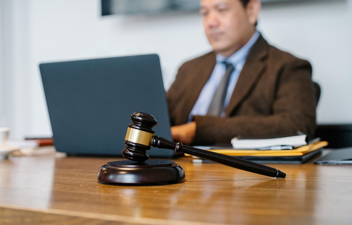 lawyer typing on a laptop at his desk with a gavel nearby